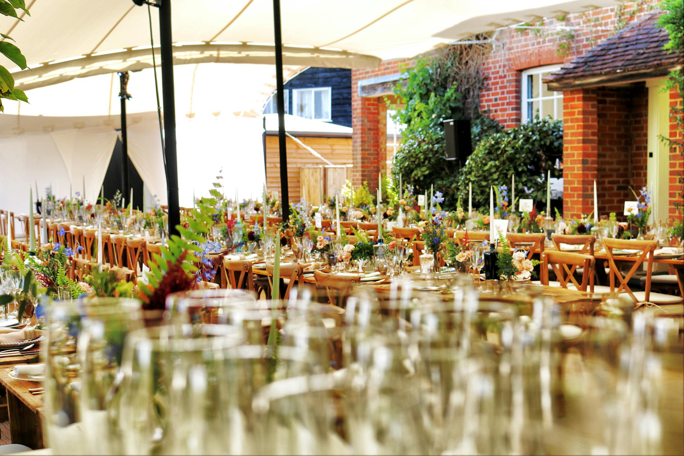 A long, candle-lit outdoor table set for a plant-based gathering